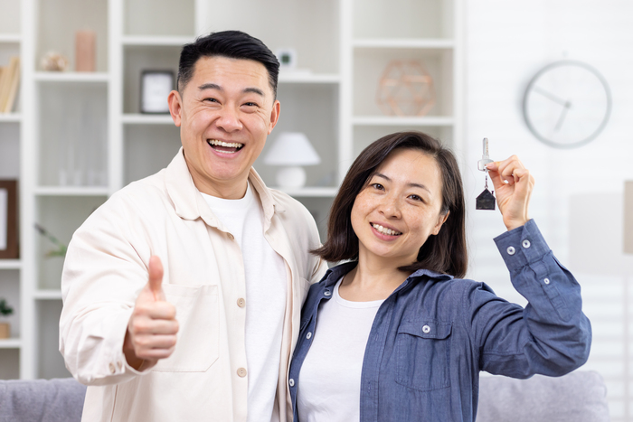 Happy couple in Singapore holding new house keys after a successful property investment guided by BaZi analysis and favourable luck cycles.